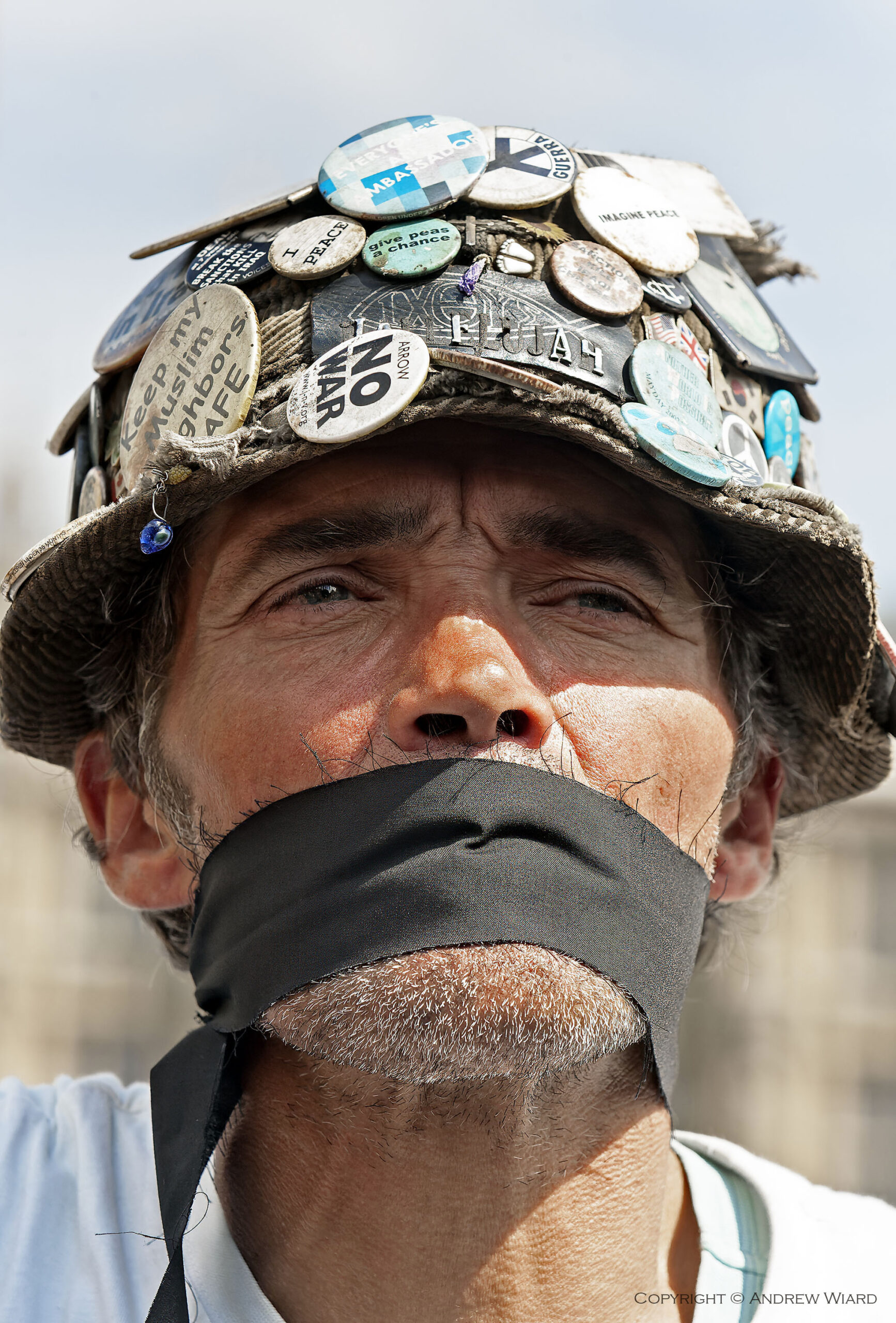 England, UK .1.8. 2005. London. Brian Haw, Parliament Square. First arrests under the exclusion order for the area around Parliament introduced by the government from today 1st August under the Serious and Organised Crime and Police Act which grants the home secretary the power to ban unauthorised protests within a half-mile radius of Parliament . Demonstrators , many wearing black gags, protested against the zone as a serious attack on civil liberties . This exclusion zone prohibits demonstrations, even one-person demonstrations, unless the police expressly permit them. Failure to comply can lead to arrest. The zone covers a very wide area around Parliament as far as the London Eye, Charing Cross embankment and up to (although not including) Trafalgar Square . The demonstrators were joined by Brian Haw, who won a legal battle to continue his anti-war vigil outside Parliament , and Lauren Booth, sister of Tony Blair's wife Cherie .

Copyright © 2005 Andrew Wiard

Supplied for publication free of charge only in connection with the exhibition of Resistance at Turner Contemporary and the Scottish National Gallery of Modern Art, Edinburgh, All Other Rights Reserved. Not for archiving.

W: www.reportphotos.com
E: info@reportphotos.com.