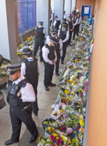 ©Licensed to London News Pictures 28/09/2020
Croydon, UK. Members of the Metropolitan Police Territorial Support Group looking at the flowers placed for Sgt Matt Ratana at Croydon Custody Centre. The murder investigation continues after the death of police sergeant Matt Ratana at the Croydon Custody Centre in South London last week. Photo credit:Grant Falvey/LNP