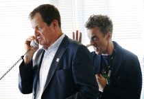 Alastair Campbell (L), communications director for former prime minister Tony Blair, speaks on a telephone as actor Peter Capaldi gestures, on the trading floor of BGC Partners, in London September 11, 2012. The company, formerly part of Cantor Fitzgerald, holds a Charity Day each year to commemorate the 658 employees who lost their lives in the 9/11 attacks on the World Trade Centre in New York. During the day celebrities visit the company to help raise money for their selected charity, by assisting the brokers deal on the trading floor. REUTERS/Luke MacGregor (BRITAIN - Tags: ANNIVERSARY BUSINESS SOCIETY POLITICS) - RTR37TT9