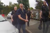 A still from his own car dashboard camera shows Peter Macdiarmid having been arrested and handcuffed.