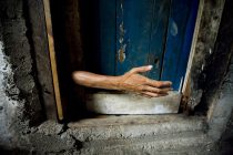 Dili, East Timor. 
A woman known as Maria reaches out from behind the door where she is locked in by her family. Maria suffers Bipolar disorder and often escapes from the chained room and goes missing putting her life in danger.
Photo by Fabio de Paola