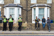 © Joel Goodman - 07973 332324 . 09/07/2011 . Cambridge , UK . Three policemen and three Asian youths sit on a wall outside a mosque as police operate community reassurance activities as the English Defence League hold a march and demonstration in Cambridge . Photo credit : Joel Goodman