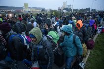 © Licensed to London News Pictures. 24/10/2016. Calais, France. A group of migrants queue to board busses as the evacuation and demolition begins at the migrant camp in Calais, known as the 'Jungle'. French authorities have given an eviction order to thousands of refugees and migrants living at the makeshift living area of the French coast. Photo credit: Ben Cawthra/LNP