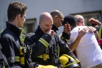 © Licensed to London News Pictures. 19/06/2017. London, UK. Firefighters who attended the scene of the fire join relatives of the victims and members of the public to observe minutes silence held near the scene of the Grenfell tower block fire. The blaze engulfed the 27-storey building killing dozens - with 34 people still in hospital, many of whom are in critical condition. Photo credit: Ben Cawthra/LNP