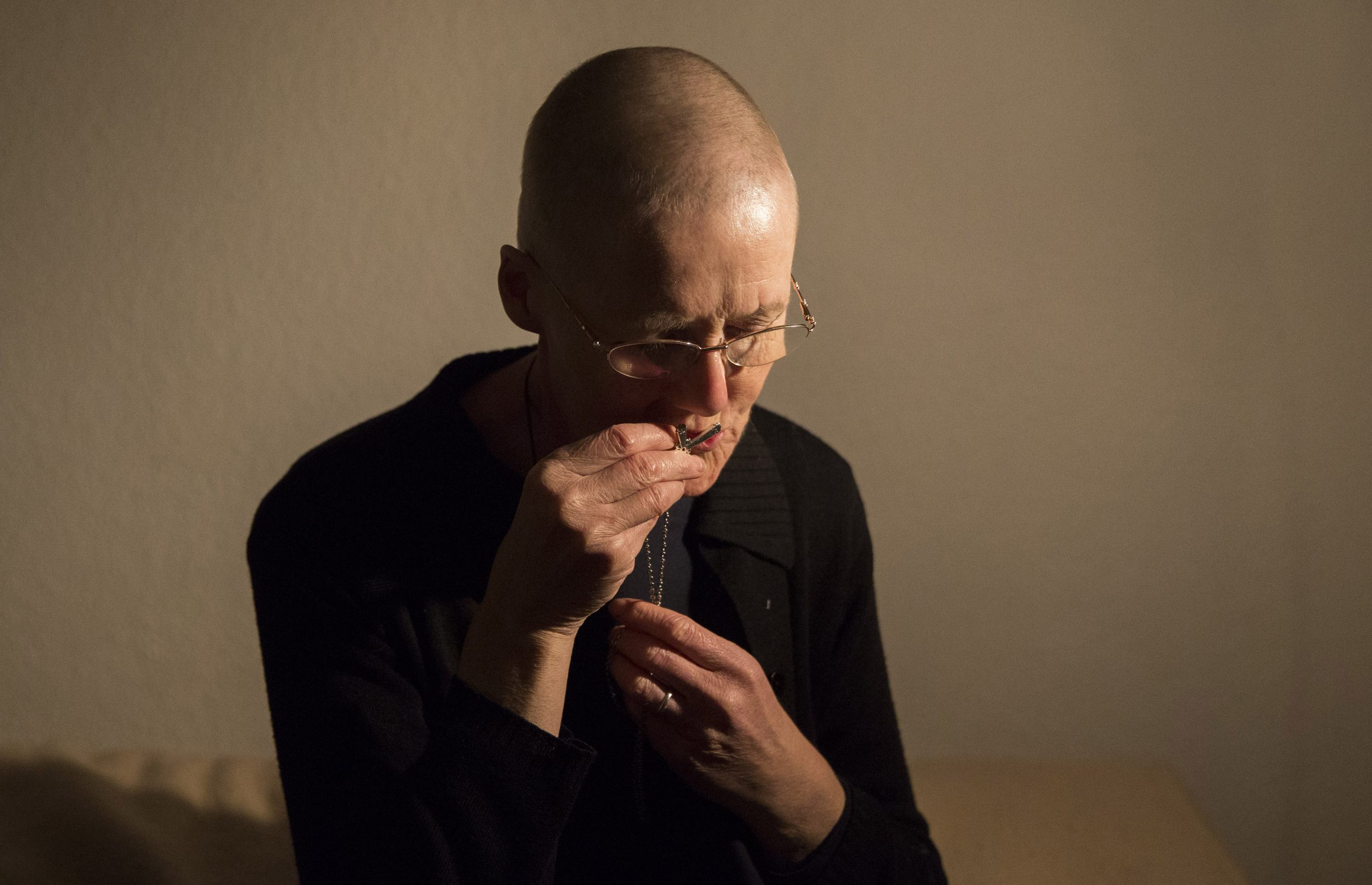 Hermit Sister Rachel Dentontakes off her cross as she prepares herself for her bed at St Cuthberts' Hermitage in Lincolnshire, north east Britain September 25, 2015. Sister Rachel Denton has vowed to spend the rest of her life living as a consecrated hermit in the Catholic faith. A hermit is a person who chooses to live alone, with the intention of finding God. Rarely leaving her house she lives a life of prayer and solitude. However, she uses the internet and social media to share her experience and distance her self from physically interacting with society. REUTERS/Neil Hall