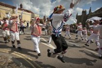 Morris Dancers perform on August Bank Holiday Monday in Thaxted, Essex, England. 26-8-2013
Thaxted Morris Men in red and white and visiting side The Blackmore Morris in blue and white perform in the Bull Ring outside the Swan pub in the traditional home of Morris Dancing in Thaxted in north west Essex, England.