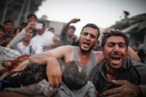 The body of a child is pulled from rubble after an aerial bombardment gin the neighbourhood of Ahadarea, Aleppo, Syria, on Tuesday 11 September [Sam Tarling]