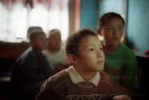 Bhutan and the arrival of television. Bhutan was the last country in the world to accept television. Here, four young schoolboys watch American cartoons on a Murdoch satellite channel. they should be doing their homework. Essay for the Guardian magazine.
