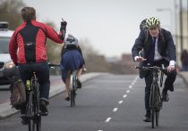 Vauxhall Bridge, London, UK. 19th November, 2015. Boris Johnson MP, was given the finger by a passing fellow cyclists as the Mayor officially launches the capital’s first fully segregated cycle superhighway by joining the morning rush-hour riders along Vauxhall Bridge. The new continuous two-way separated cycle lane runs for 1.4 kilometres from Kennington Oval to Pimlico, offering a safe cycle-friendly route for all ages and abilities through Vauxhall gyratory and across Vauxhall Bridge.  // Lee Thomas, Flat 47a Park East Building, Bow Quarter, London, E3 2UT. Tel. 07784142973. Email: leepthomas@gmail.com. www.leept.co.uk (0000635435)