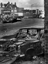 Boy in car - 1980 Salford
I was wondering around the Salford area when I came upon this boy playing in a burnt out car.  There was a travelling ëspeedwayí circus parked up on the waste ground.   The MUFC OK graffiti on the car makes it so Manchester.
