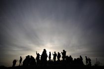 People are silhouetted as the sun sets on a winters afternoon in Primrose Hill in London, Britain January 16, 2016. REUTERS/Neil Hall