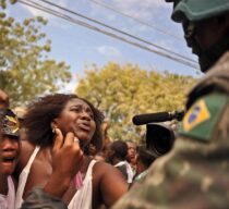 A mother pleads with a Brazilian slodier for food for her child